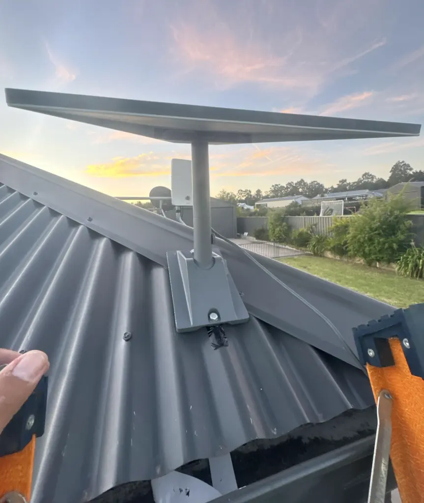 Starlink dish on a pivot mount installed on a tin roof