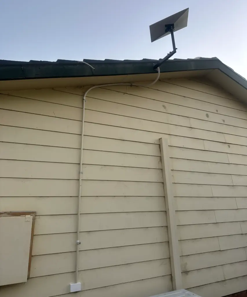 Starlink dish relocated to a wall mount under the eaves